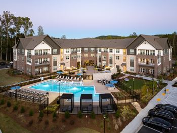 A large building with a pool in front of it.